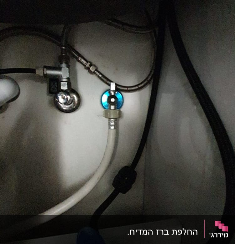 צינורות מתכת ופלסטיק מתחת לכיור